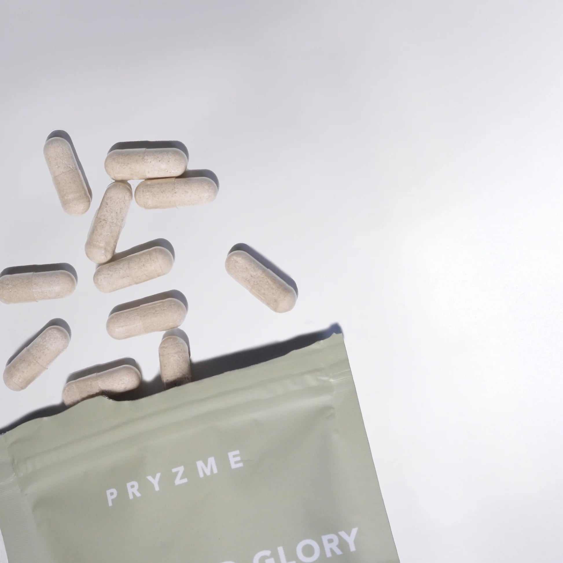 Pills spilling out of a 'PRYZME' bag on a light gray background